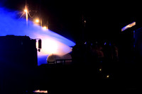 The teams work to put out the propane tank fire. I like the blue emergency light making the water look blue.